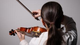 Ett barn spelar violin.